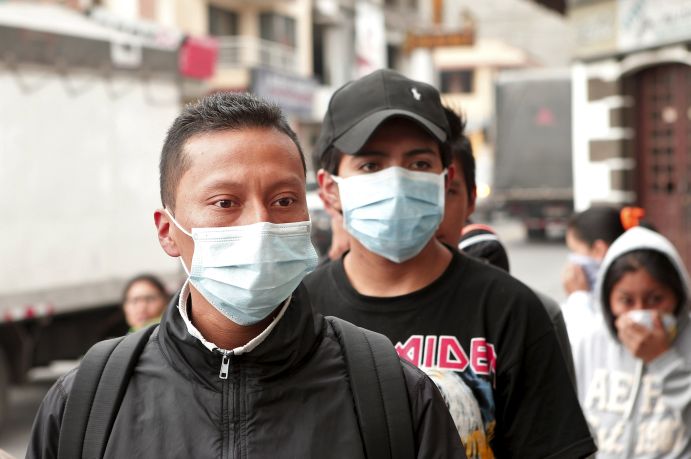 People wear surgical masks to protect themselves from volcanic ash in Machachi