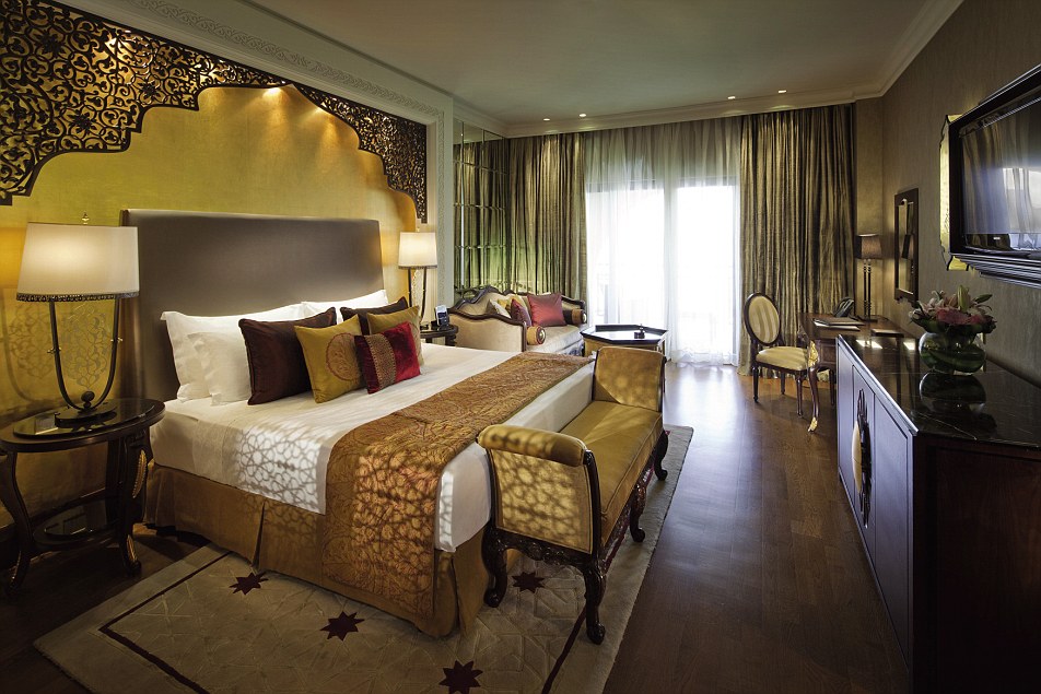 A deluxe king room at the hotel was golden and glamorous, with a multitude of cushions and plush furnishings