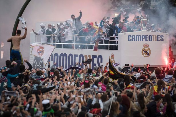 Real Madrid football club supporters celebrate as the team arrives on Plaza Cibeles in Madrid on May 29, 2016