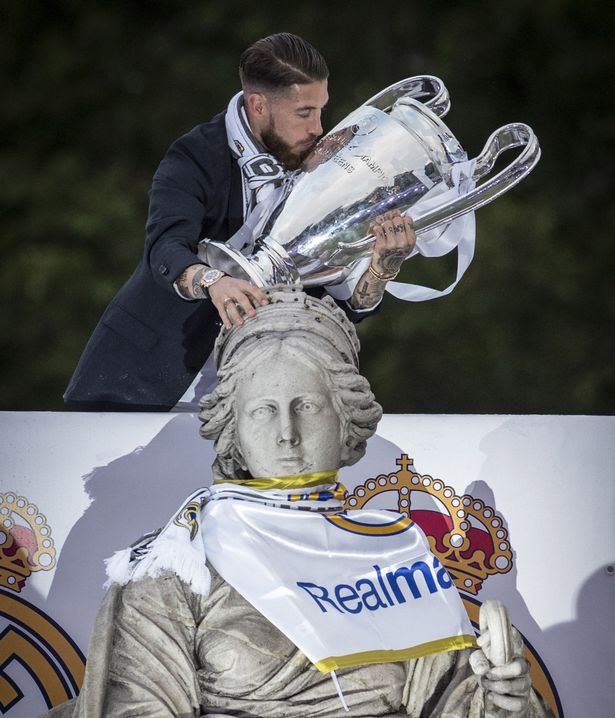 Real Madrid's defender Sergio Ramos kisses the trophy in celebration of the team's win on Plaza Cibeles in Madrid on May 29, 2016