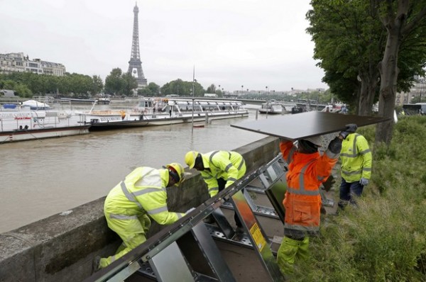 Workers install temporary aqua-barriers above the flooded banks of the River Seine near the Eiffel tower in Paris after days of almost non-stop rain caused flooding in the country