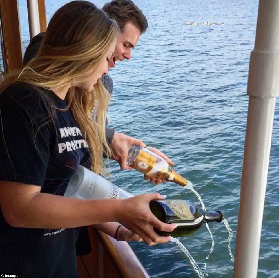 Wasteful? Kyle Parsons posted a snap showing him and a female friend 'saying goodbye' to some Dom Perignon, Cristal and a little Belvedere by pouring it into the sea