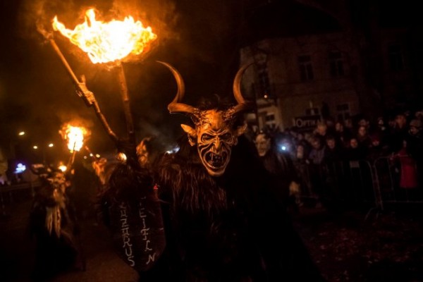   Participants dressed as the Krampus creatures walk the streets during Krampus gathering on December 12, 2015 in Kaplice, Czech Republic. Krampus, also called Tuifl or Perchten, is a demon-like creature represented by a fearsome, hand-carved wooden mask with animal horns, a suit made from sheep or goat skin and large cow bells attached to the waist that the wearer rings by running or shaking his hips up and down. Krampus has been a part of Central European, alpine folklore going back at least a millennium, and since the 17th-century Krampus traditionally accompanies St. Nicholas and angels on the evening of December 5 to visit households to reward children that have been good while reprimanding those who have not. However, in the last few decades the western Austrian region of Tyrol in particular has seen the founding of numerous village Krampus associations with up to 100 members each and who parade without St. Nicholas at Krampus events throughout November and early December. In the last few years, Czech towns, placed on the border with Austria, invite Austrian Krampus groups into towns for parades as a new tradition during Advent. (Photo by Matej Divizna/Getty Images)