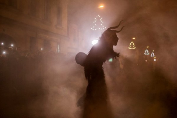   A participant dressed as the Krampus creature walks the streets during Krampus gathering on December 12, 2015 in Kaplice, Czech Republic. Krampus, also called Tuifl or Perchten, is a demon-like creature represented by a fearsome, hand-carved wooden mask with animal horns, a suit made from sheep or goat skin and large cow bells attached to the waist that the wearer rings by running or shaking his hips up and down. Krampus has been a part of Central European, alpine folklore going back at least a millennium, and since the 17th-century Krampus traditionally accompanies St. Nicholas and angels on the evening of December 5 to visit households to reward children that have been good while reprimanding those who have not. However, in the last few decades the western Austrian region of Tyrol in particular has seen the founding of numerous village Krampus associations with up to 100 members each and who parade without St. Nicholas at Krampus events throughout November and early December. In the last few years, Czech towns, placed on the border with Austria, invite Austrian Krampus groups into towns for parades as a new tradition during Advent.?  (Photo by Matej Divizna/Getty Images)