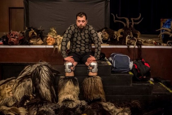   A participant dressed as the Krampus creature rests in the backstage before Krampus gathering on December 12, 2015 in Kaplice, Czech Republic. Krampus, also called Tuifl or Perchten, is a demon-like creature represented by a fearsome, hand-carved wooden mask with animal horns, a suit made from sheep or goat skin and large cow bells attached to the waist that the wearer rings by running or shaking his hips up and down. Krampus has been a part of Central European, alpine folklore going back at least a millennium, and since the 17th-century Krampus traditionally accompanies St. Nicholas and angels on the evening of December 5 to visit households to reward children that have been good while reprimanding those who have not. However, in the last few decades the western Austrian region of Tyrol in particular has seen the founding of numerous village Krampus associations with up to 100 members each and who parade without St. Nicholas at Krampus events throughout November and early December. In the last few years, Czech towns, placed on the border with Austria, invite Austrian Krampus groups into towns for parades as a new tradition during Advent. (Photo by Matej Divizna/Getty Images)