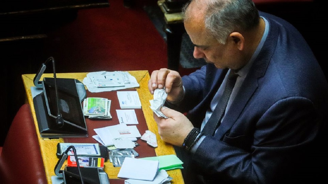 Βουλή: Ο Σαρίδης περιεργάζεται προσωπικά του αντικείμενα – Αράδειασε στο έδρανο μαντιλάκια και αποκόμματα ΟΠΑΠ! (φωτο)