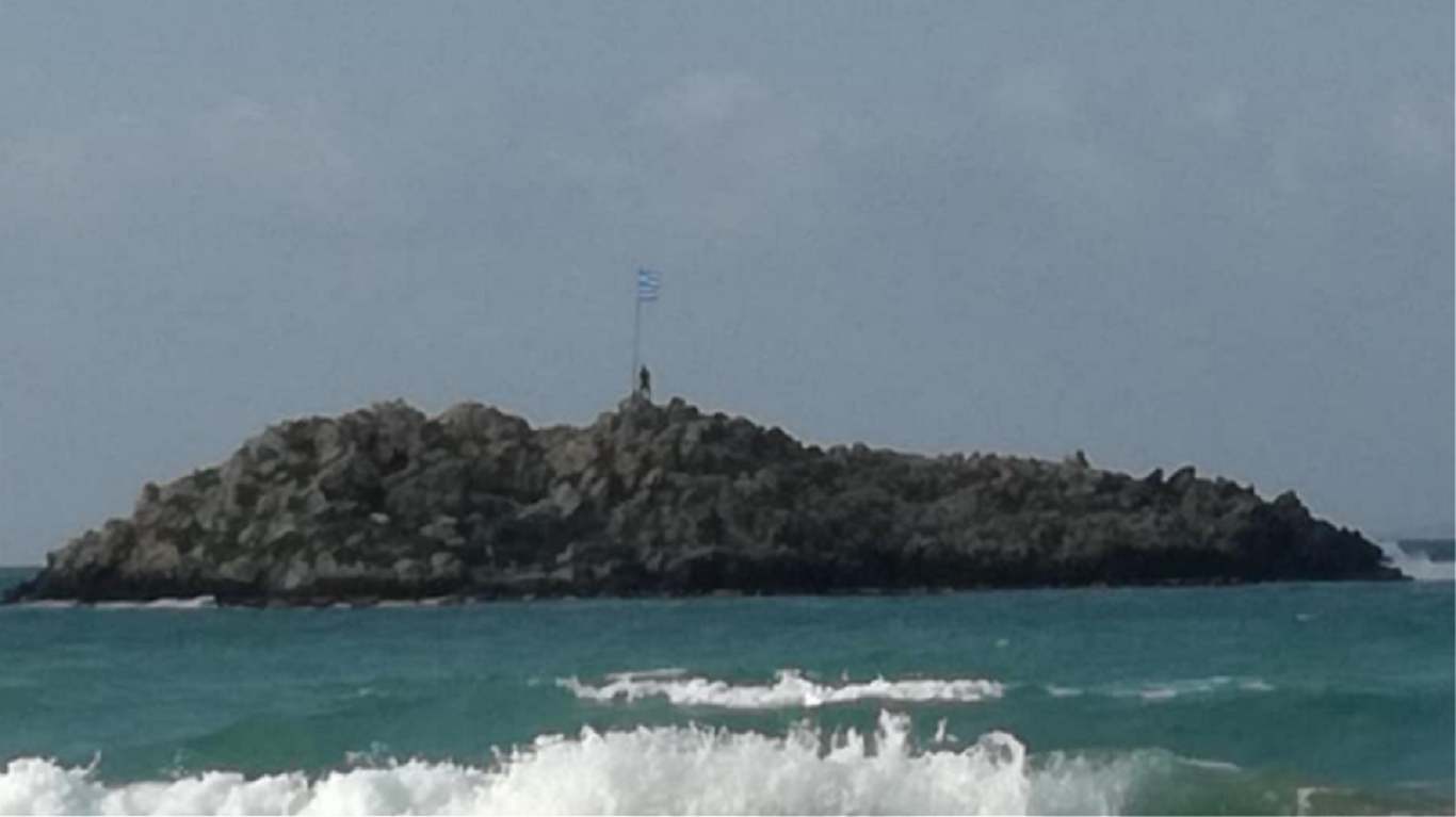 Κρήτη: Βούτηξε στα κρύα νερά για να αλλάξει μία παλιά και κουρελιασμένη σημαία σε νησάκι!