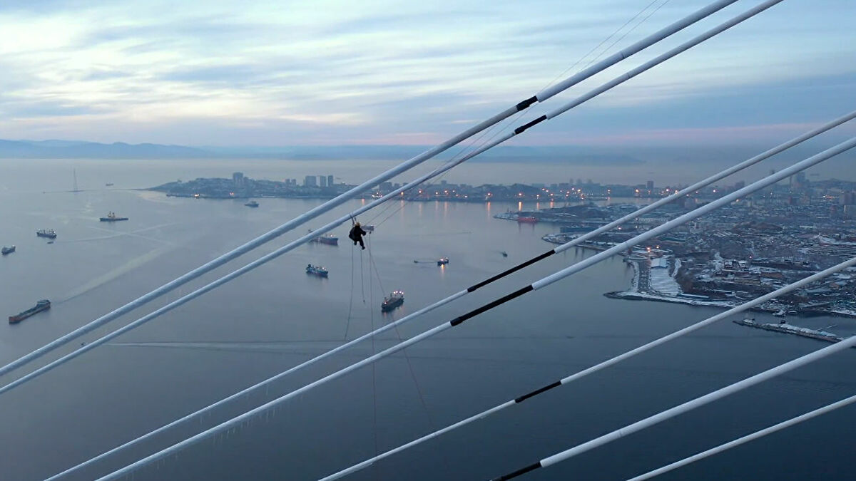 Άνδρας καθαρίζει τον πάγο από γέφυρα σε ύψος που «κόβει» την ανάσα (βίντεο)