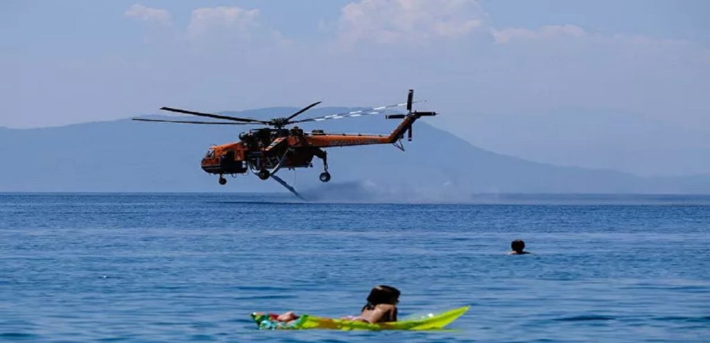 Φωτιά στα Βίλια: Λουόμενοι απολαμβάνουν το μπάνιο τους ενώ ελικόπτερα φορτώνουν νερό (φώτο)
