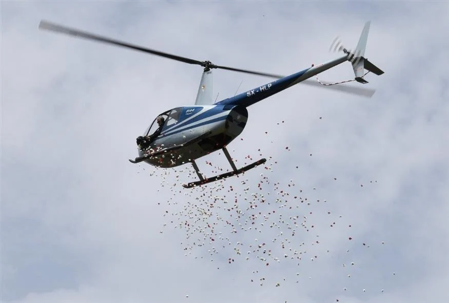 Ο πιλότος Μ.Πουλικάκος ραίνει εικόνα της Παναγίας με ροδοπέταλα από το ελικόπτερό του στον Αυλώνα Αττικής