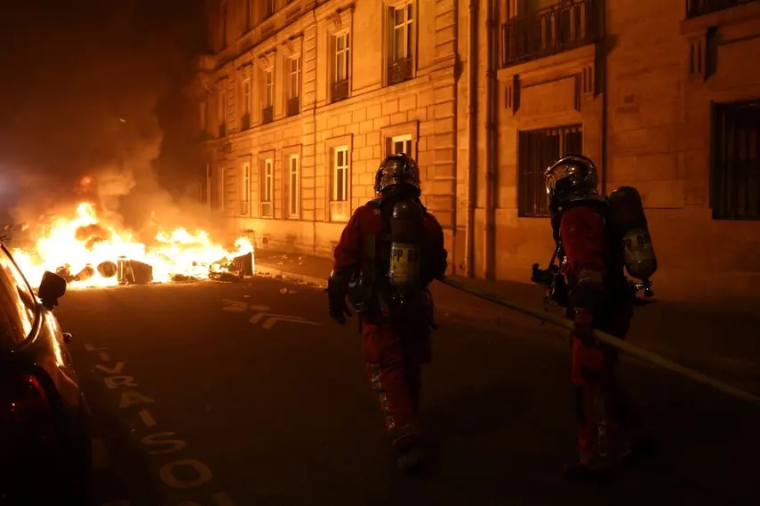 Παρίσι: Ατάραχοι Γάλλοι πίνουν το απεριτίφ τους ενώ φωτιές καίνε στον δρόμο