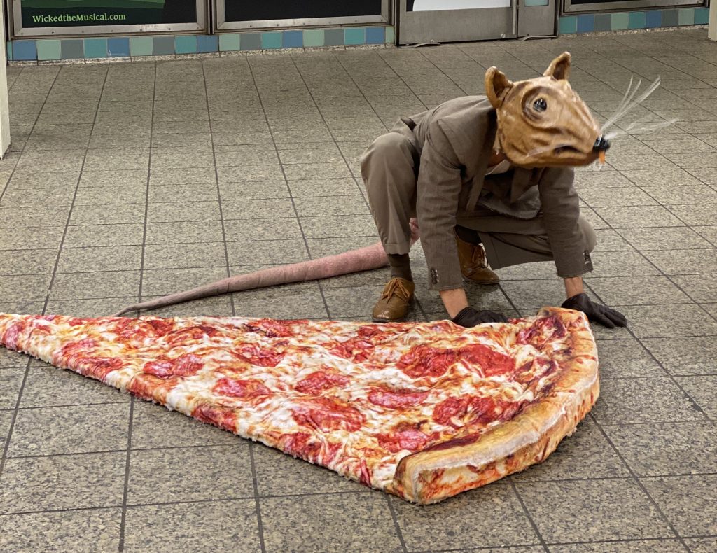 Απίστευτη παρακμή στις ΗΠΑ: Κυκλοφορεί ντυμένος ως ποντικός στο μετρό της Νέας Υόρκης μεταφέροντας μία τεράστια «πίτσα»!