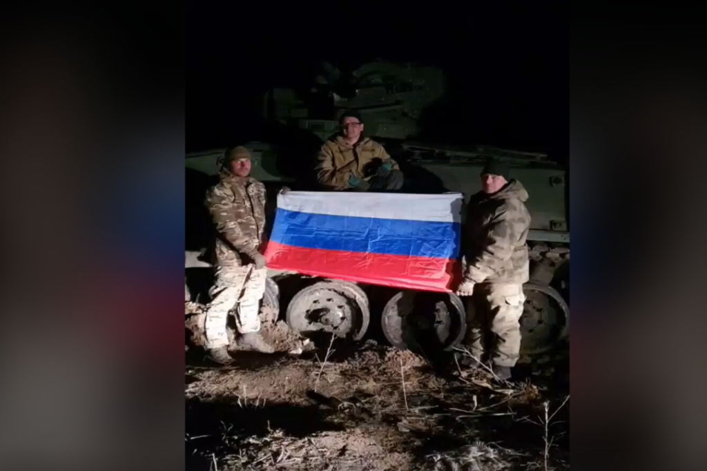 Μέλη της Σλαβικής Ταξιαρχίας επιδεικνύουν την σημαία τους μπροστά σε ένα κατεστραμμένο γερμανικό ΤΟΜΑ Marder-1A3